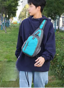 Outdoor waterproof sling bag detail showing functional zipper layers and turquoise nylon fabric