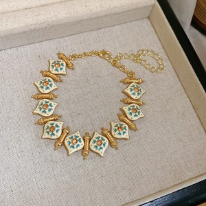 Detailed shot of a vintage gold bracelet with enamel and rhinestones in a jewelry box