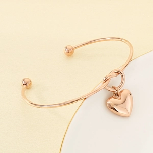 Gros plan du bracelet à nœud plaqué or rose 18K avec pendentif cœur et finition polie