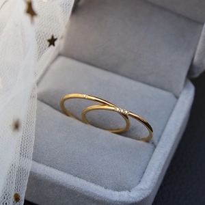 Polished gold minimalist zircon rings in single and triple stone styles on velvet
