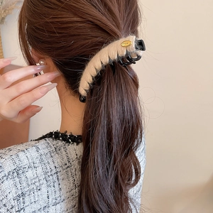 Vue détaillée d'une pince à cheveux en peluche crème pour une coiffure élégante et chic