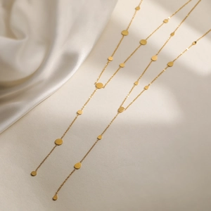 Chic gold-plated stainless steel chain necklace with circular charms on silk background