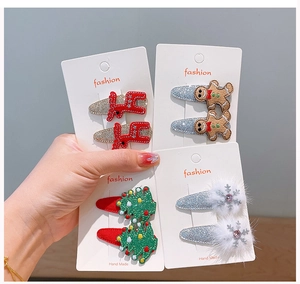 Detail of four sets of festive Christmas hair clips featuring reindeer and trees