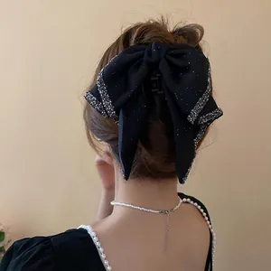 Elegant black bow hair claw clip with silver rhinestone trim for stylish updos