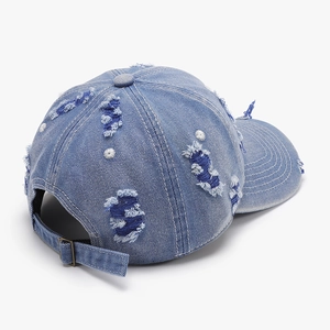 Rear view of washed denim baseball cap with distressed details and metal buckle adjustment