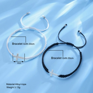 Black and white woven friendship bracelets with silver cross charms on blue background