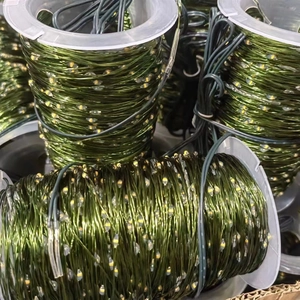 Detail of green copper wire LED string lights wound on transparent plastic spools