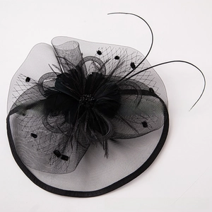 Detail view of black vintage fascinator hat with feather and mesh polka dot accents