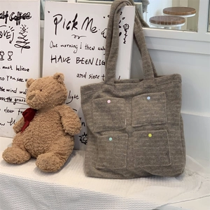 Close-up of brown wool felt tote bag featuring four pockets with colorful decorative buttons