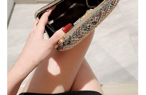 Detail of evening clutch bag featuring colorful rhinestones and a metal chain strap