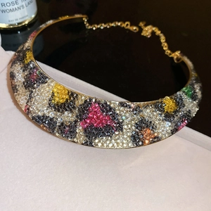 Macro shot of luxury golden choker with vibrant colorful leopard print rhinestone crystals