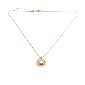 Detail of gold pendant featuring a teardrop gem with sunburst texture on box chain