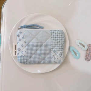 Detail of quilted cotton floral coin purse with blue checkered patterns and zip tie
