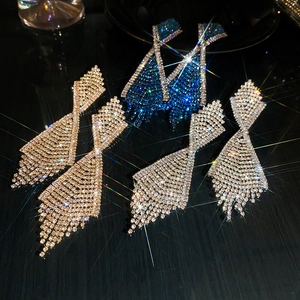 Macro shot of tassel drop earrings in gold, blue, and silver with sparkling rhinestones
