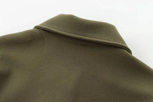Détail du col d'un manteau en laine vert olive montrant la texture des coutures
