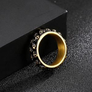 Detail eines Punk-Totenkopfrings mit goldener Innenseite und schwarzem Relief-Design