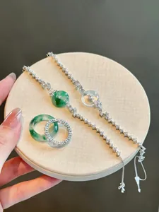Dettaglio ravvicinato di bracciali e anelli in giada verde smeraldo con pavé di zirconi