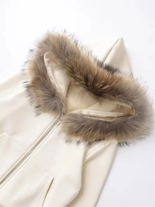 Detailed close-up of fluffy fur collar and zipper on beige hooded sweatshirt jacket