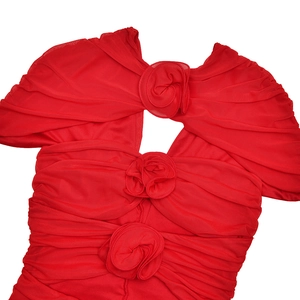 Detailed view of red ruched mesh dress featuring three 3D flower accents and V-neckline