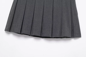 Detailed macro view of dark grey pleated fabric and precision stitching on the hemline