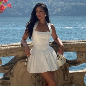 Détail de la robe courte blanche à licou avec jupe trapèze et fini satiné au lac