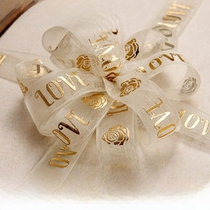 Detail showing sheer organza ribbon with gold stamped roses and LOVE lettering bow