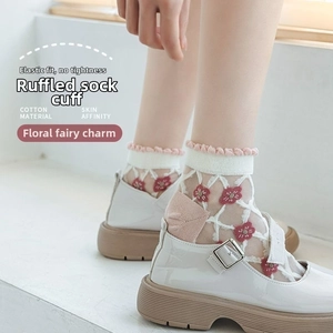 Detail von Spitzen-Baumwollsocken mit Blumenstickerei und weißen Mary Jane Schuhen