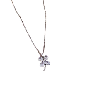 Silver titanium clover necklace with sparkling zircon crystals on white background