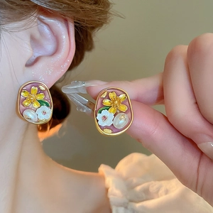 Macro shot of French vintage flower stud earrings with pink oil drop finish and pearls