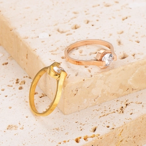 Anelli in oro e oro rosa con numeri romani e zircone su base in pietra beige