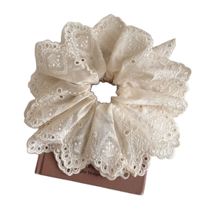 Beige floral lace embroidered scrunchie shown on vintage books with a retro design
