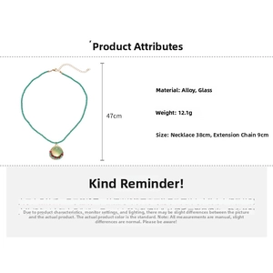 Detailed view of green crystal beads and round glass pendant on 38cm vintage necklace