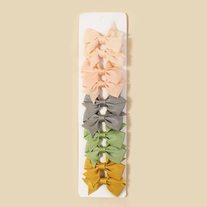 Detailed set of eight ribbed grosgrain ribbon hair bows in pink, grey, green, and yellow