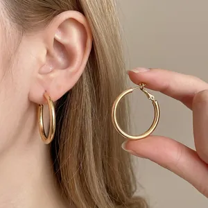 Minimalist large golden hoop earrings with high-polished metallic finish for women