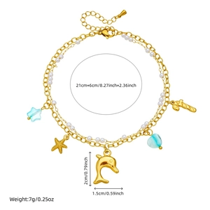 Gold double-layer anklet with starfish, dolphin pendants and pearls on a white background