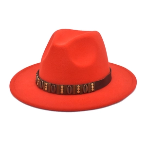 Close-up of red wool felt fedora featuring a brown belt with metallic shell accents