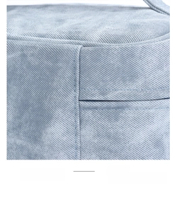 Close-up of double-stitched reinforced edges on light blue denim fabric cosmetic bag