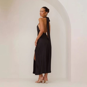 Detail of elegant black satin halter dress with an open back and high side slit design
