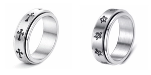 Close-up of rotatable silver stainless steel spinner rings with cross and turtle patterns