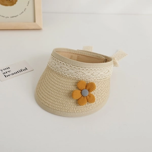 Detail of woven straw sun hat with white lace trim and a small yellow flower accent