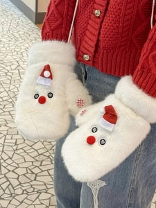 Close-up of white plush mittens featuring a festive red Santa hat and fluffy faux fur texture