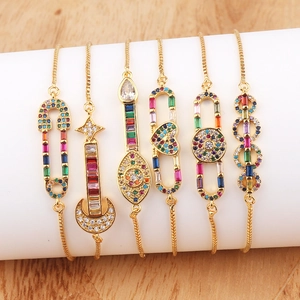 Adjustable 18K gold-plated bracelets featuring diverse CZ charms on a display stand