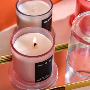 Candela profumata in cera di soia in vetro rosa con fiamma calda e luminosa