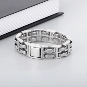 Macro detail of men's stainless steel H-link bracelet with a secure magnetic clasp