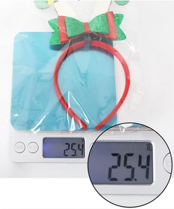 Christmas reindeer headband weighed on an electronic scale showing a weight of 25.4 grams