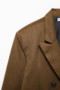 Detail view of brown faux suede blazer collar and shoulder stitching with double-breasted buttons