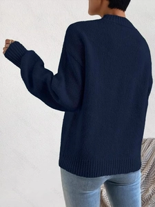 Navy blue crewneck knit sweater with ribbed cuffs and textured finish, back view on model