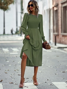 Détail d'une robe longue vert armée à manches longues, taille élastique et ourlet à volants