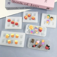 Food-grade silicone molds for mini French fries and ice cream shapes on a gray surface