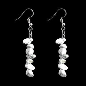 Detail view of long irregular white marble stone beads on silver metal earring hooks